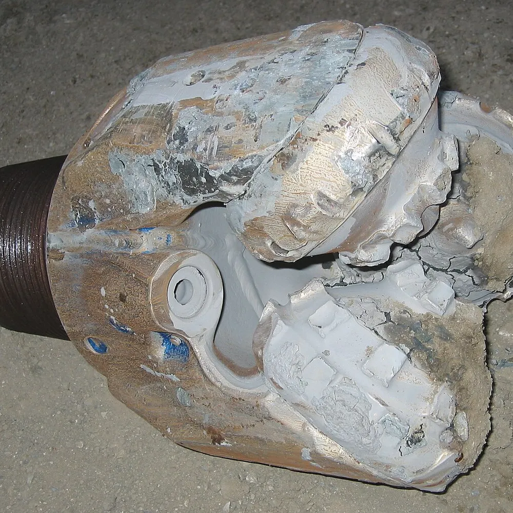 Heavily worn roller cone bit showing individual cones and bearing area